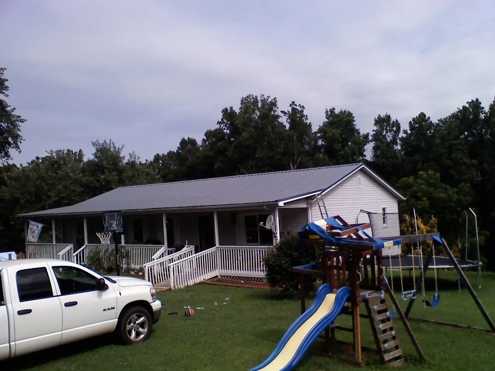 Dark metal roof on a country home with a full length front porch in Altamont