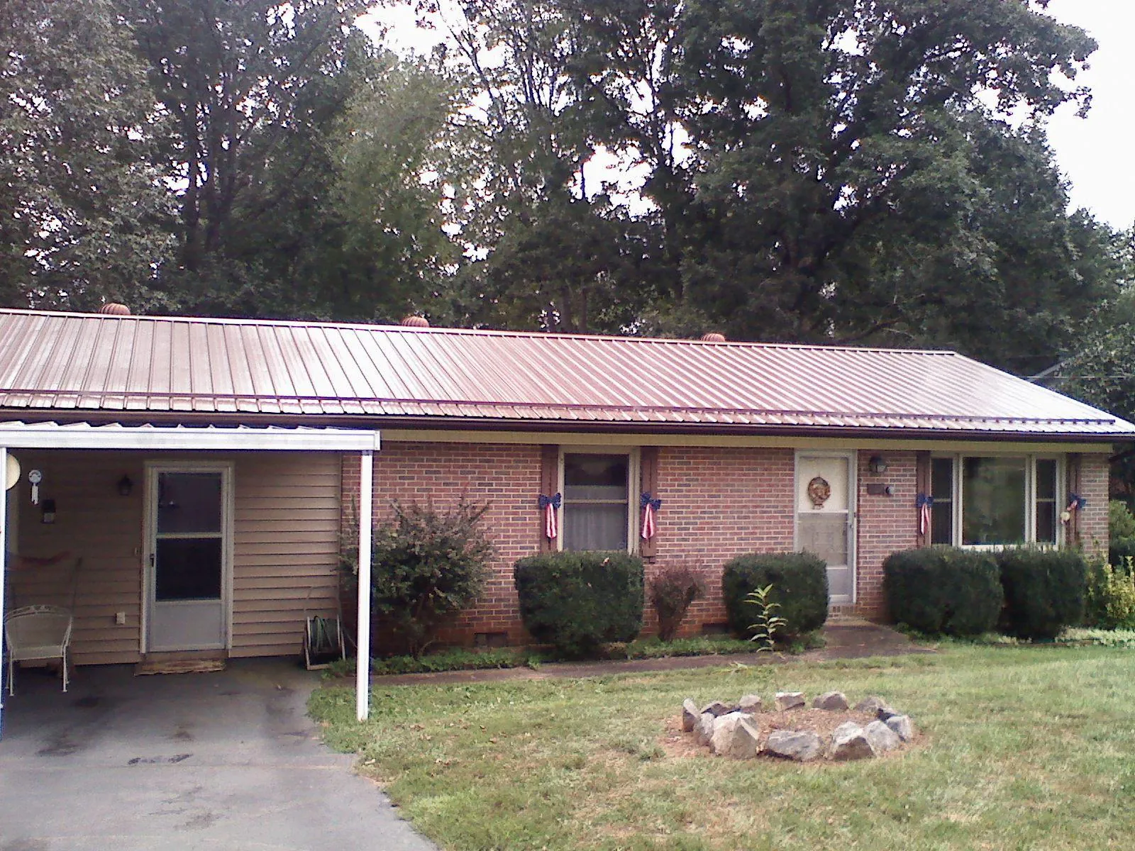 Bronze metal roof and carport on a brick ranch home — Roof Repair work by our crew in Altamont